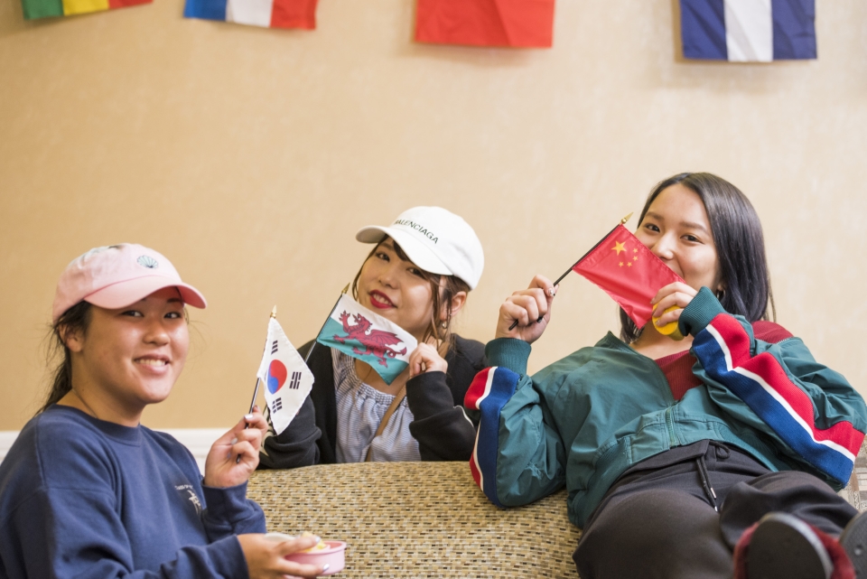 students waving flags from different countries